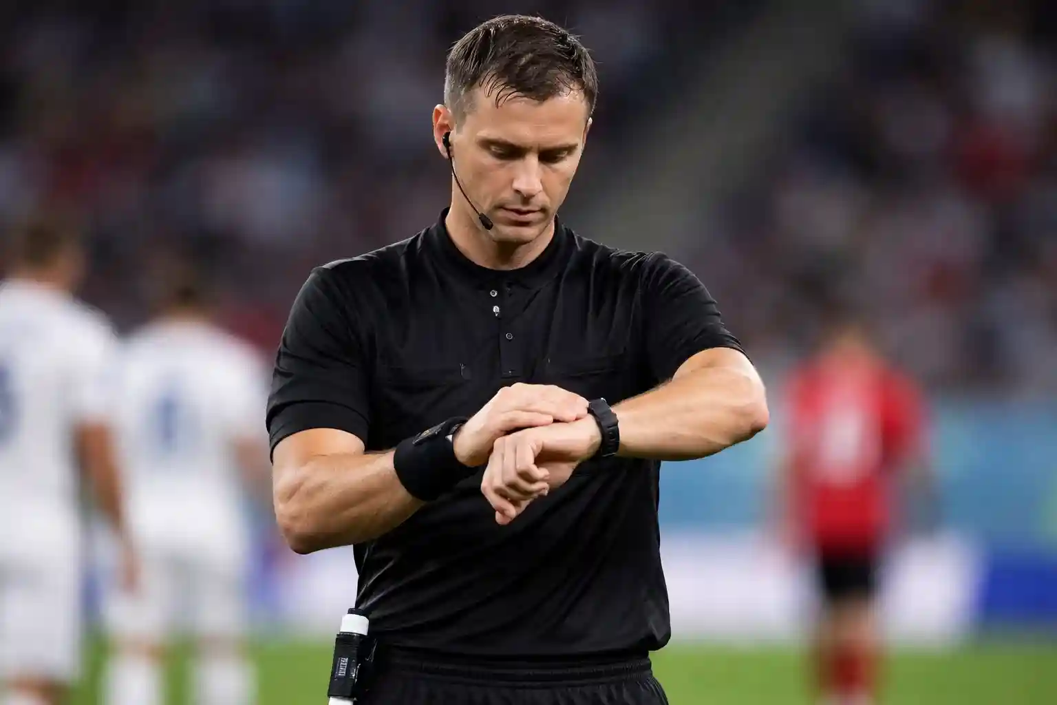 Arbitro che controlla l'orologio durante il primo tempo di una partita